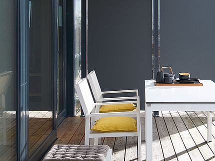 Outdoor furniture A sunny terrace with outdoor furniture and a partition wall made of Compact XTerior.
