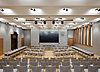 The photo shows the great hall of the new town hall. It features a big screen, light materials and some wooden elements.