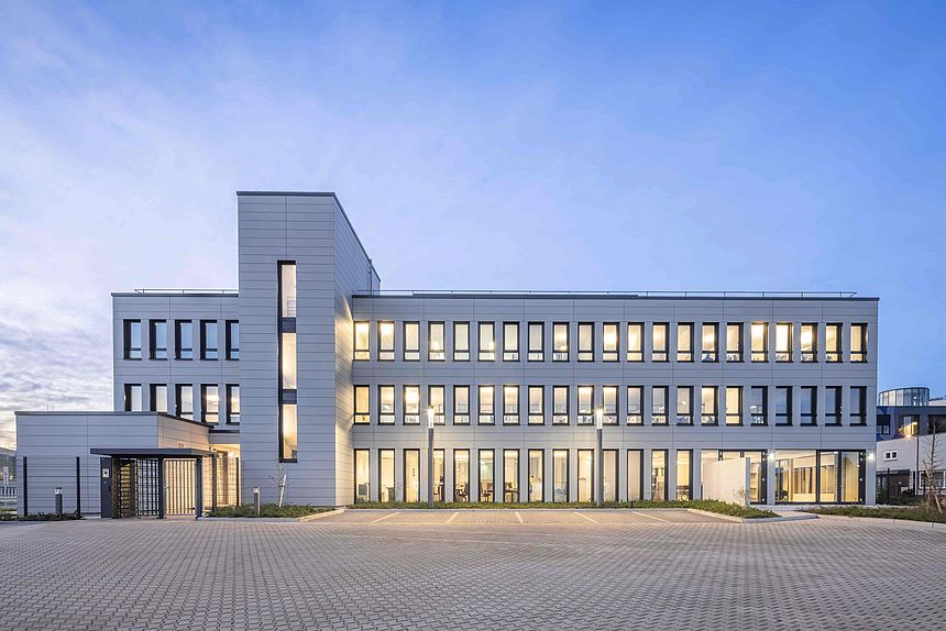 Immeuble de bureaux avec façade grise et fenêtres éclairées